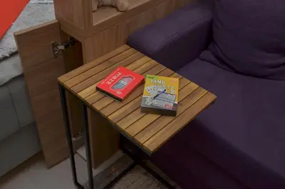a table with a book on it next to a bed at Apartman Enjoy N82 Milmari&spa in Kopaonik