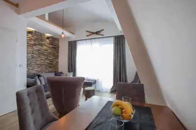 a living room with a dining room table and chairs at Pano Kopaonik Panorama in Kopaonik