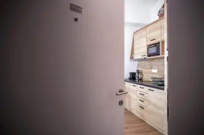 an open door to a kitchen with wooden cabinets at Pano Kopaonik Panorama in Kopaonik