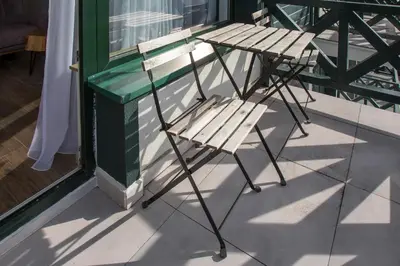 two wooden chairs sitting on a porch next to a window at Pano Kopaonik Panorama in Kopaonik