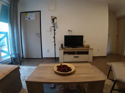 a living room with a television and a table with a bowl on it at Ajrin Apartman Kopaonik in Kopaonik