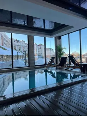 a swimming pool with lounge chairs in a building at Apartman Lorena N70a in Kopaonik