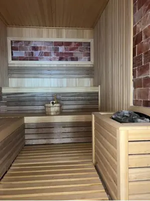 a sauna with wooden floors and a brick wall at Apartman Lorena N70a in Kopaonik