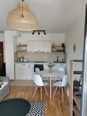 a kitchen and living room with a table and chairs at Apartman Kardaš in Vrnjačka Banja