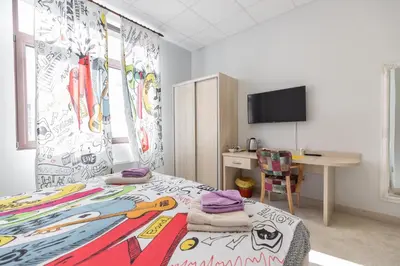 a bedroom with a bed and a desk and a tv at SMART in Niš