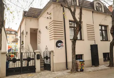 a white house with a black gate and a tree at SMART in Niš