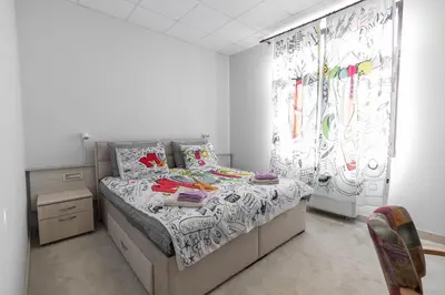 a bedroom with a bed and a chair in it at SMART in Niš