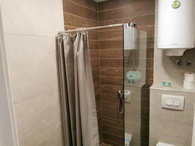 a bathroom with a shower with a shower curtain at SkyKop Apartman L21 in Kopaonik
