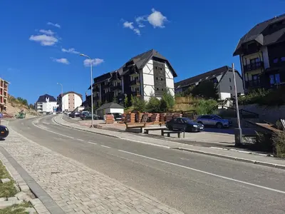 a street with cars parked on the side of the road at SkyKop Apartman L21 in Kopaonik