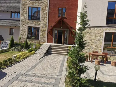 a brick house with a staircase leading to the front door at SkyKop Apartman L21 in Kopaonik