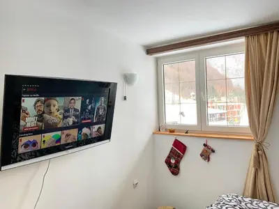 a flat screen tv hanging on a white wall at Ski-in & Ski-out, Apartman Filip - 30m from GONDOLA Brzeće in Kopaonik