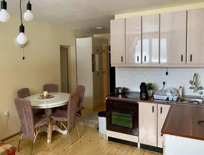 a kitchen with a table and a small table and a table and chairs at Ski-in & Ski-out, Apartman Filip - 30m from GONDOLA Brzeće in Kopaonik