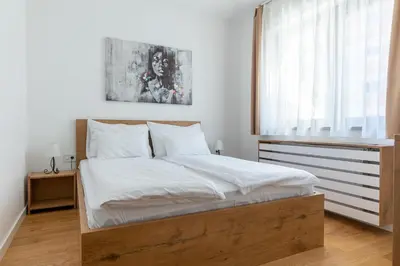 a bedroom with a bed with white sheets and a window at Vidik Residence in Kopaonik