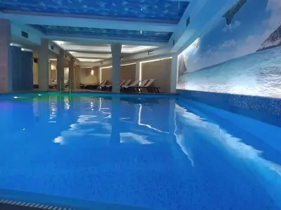 a swimming pool with blue water in a hotel at Kopaonik Milmari Mili P75 in Kopaonik