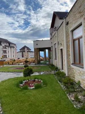 a building with a green lawn in front of a building at Kopaonik Milmari Mili P75 in Kopaonik