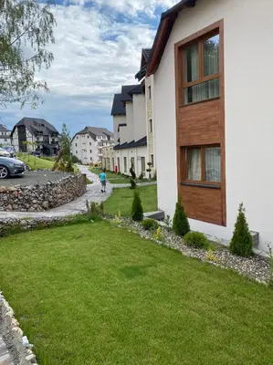 a house with a green lawn in front of it at Kopaonik Milmari Mili P75 in Kopaonik