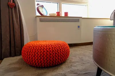 an orange ottoman sitting on the floor in a room at Apt in the Sky - Kopaonik Kraljevi Čardaci in Kopaonik