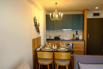 a kitchen with a table with chairs and a chandelier at Apt in the Sky - Kopaonik Kraljevi Čardaci in Kopaonik