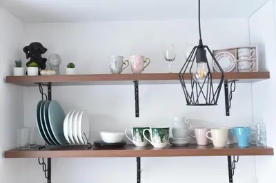a shelf with bowls and plates and a pendant light at Pegaz Premium Apartman Privatan Parking in Kopaonik