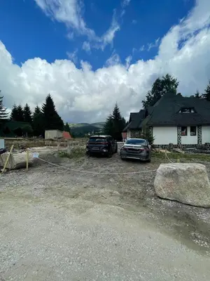 two cars parked in front of a house at Pegaz Premium Apartman Privatan Parking in Kopaonik