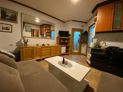 a living room with a couch and a kitchen at Vila Plan 303 Kopaonik in Kopaonik