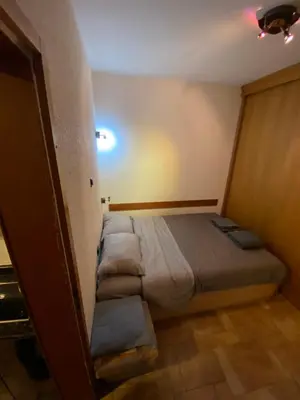 a small bedroom with a bed with pillows on it at Vila Plan 303 Kopaonik in Kopaonik