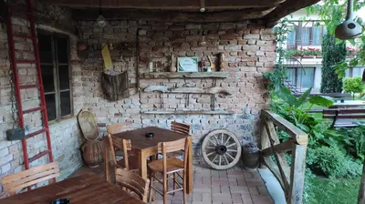 a patio with a table and chairs and a brick wall at Apartman 1 Miljković in Soko Banja
