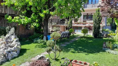 a garden with a bench and a building at Apartman 1 Miljković in Soko Banja