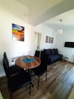 a living room with a table and chairs and a couch at Apartman 1 Miljković in Soko Banja