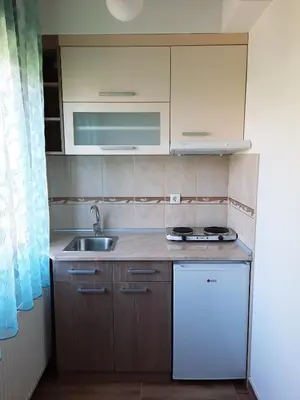 a small kitchen with a sink and a refrigerator at Apartman 1 Miljković in Soko Banja