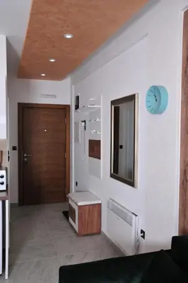 a hallway with a door and a clock on a wall at Milmari N 20 Resort in Kopaonik