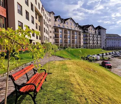 a park bench in front of a large building at Apartman “N 17”Milmari-Kopaonik in Kopaonik