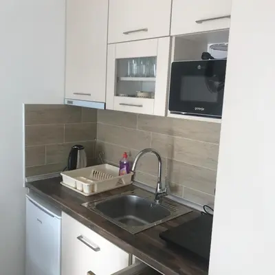 a kitchen with white cabinets and a sink at Apartman “N 17”Milmari-Kopaonik in Kopaonik