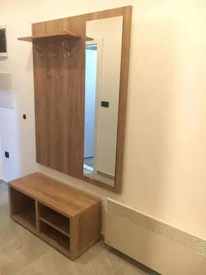 a dressing room with a mirror and a wooden cabinet at Apartman “N 17”Milmari-Kopaonik in Kopaonik