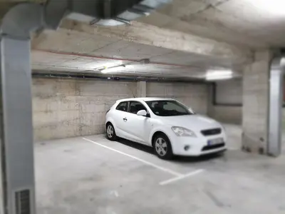 a white car parked in a parking lot at Apartman Maximus in Vrnjačka Banja