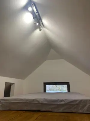 a bedroom with a bed in a white room at Dvosobni apartmani KopaNiK, Kopaonik (Brzece) in Brzeće