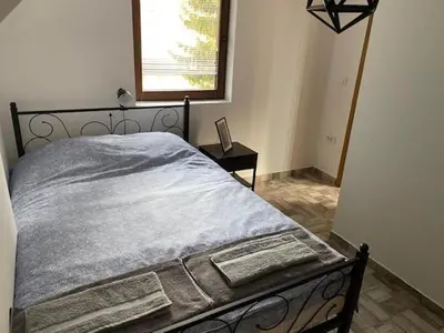 a bedroom with a bed with a blanket on it at Dvosobni apartmani KopaNiK, Kopaonik (Brzece) in Brzeće