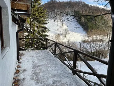 a balcony of a house with snow on the ground at Dvosobni apartmani KopaNiK, Kopaonik (Brzece) in Brzeće