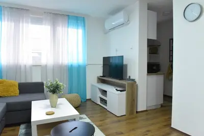 a living room with a couch and a tv at Central Apartment in Ćuprija
