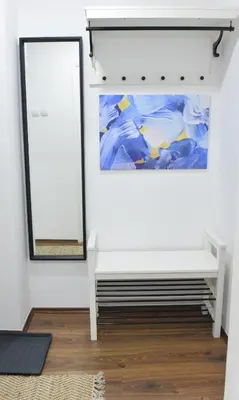 a room with a white bench and a mirror at Central Apartment in Ćuprija