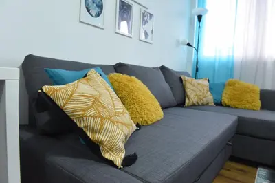 a blue couch with pillows on it in a living room at Central Apartment in Ćuprija