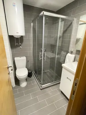 a bathroom with a shower and a toilet and a sink at Apartments Enzo Kopaonik in Kopaonik