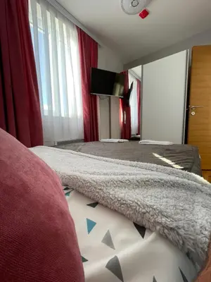 a bedroom with two beds and a flat screen tv at Apartments Enzo Kopaonik in Kopaonik