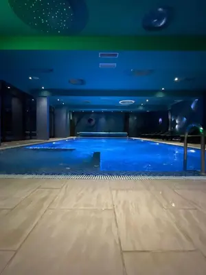 a swimming pool with blue water in a building at Apartments Enzo Kopaonik in Kopaonik
