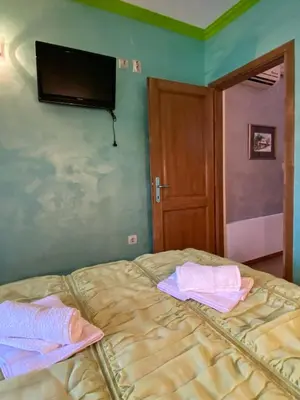 a bedroom with a bed with a flat screen tv on the wall at Apartman Marko B in Vrnjačka Banja