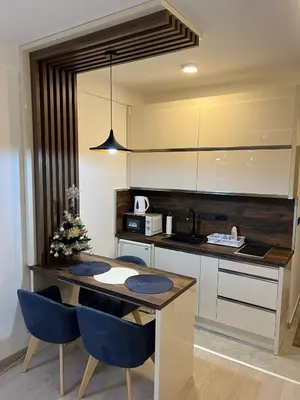 a kitchen with a table and some blue chairs at Apartman Holiday in Kopaonik