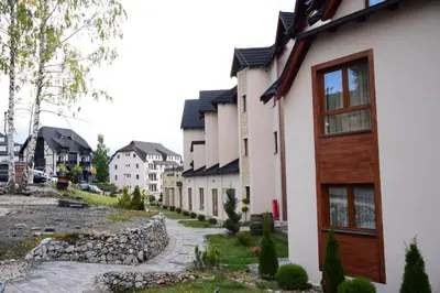 a row of houses in a town with a sidewalk at Apartman Holiday in Kopaonik