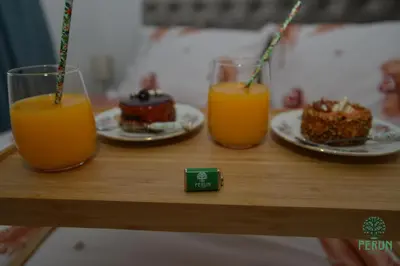three glasses of orange juice and cakes on a table at PERUN in Vrnjačka Banja