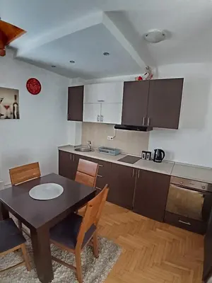 a kitchen with a table and a table and chairs at Wolf Apartments Kopaonik in Kopaonik
