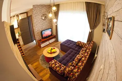 a living room with a purple couch and a table at Wolf Apartments Kopaonik in Kopaonik